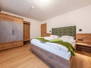 Ein Schlafzimmer mit einem hölzernen Bett, einem Kleiderschrank und einem Kopfteil mit Blumenmuster.