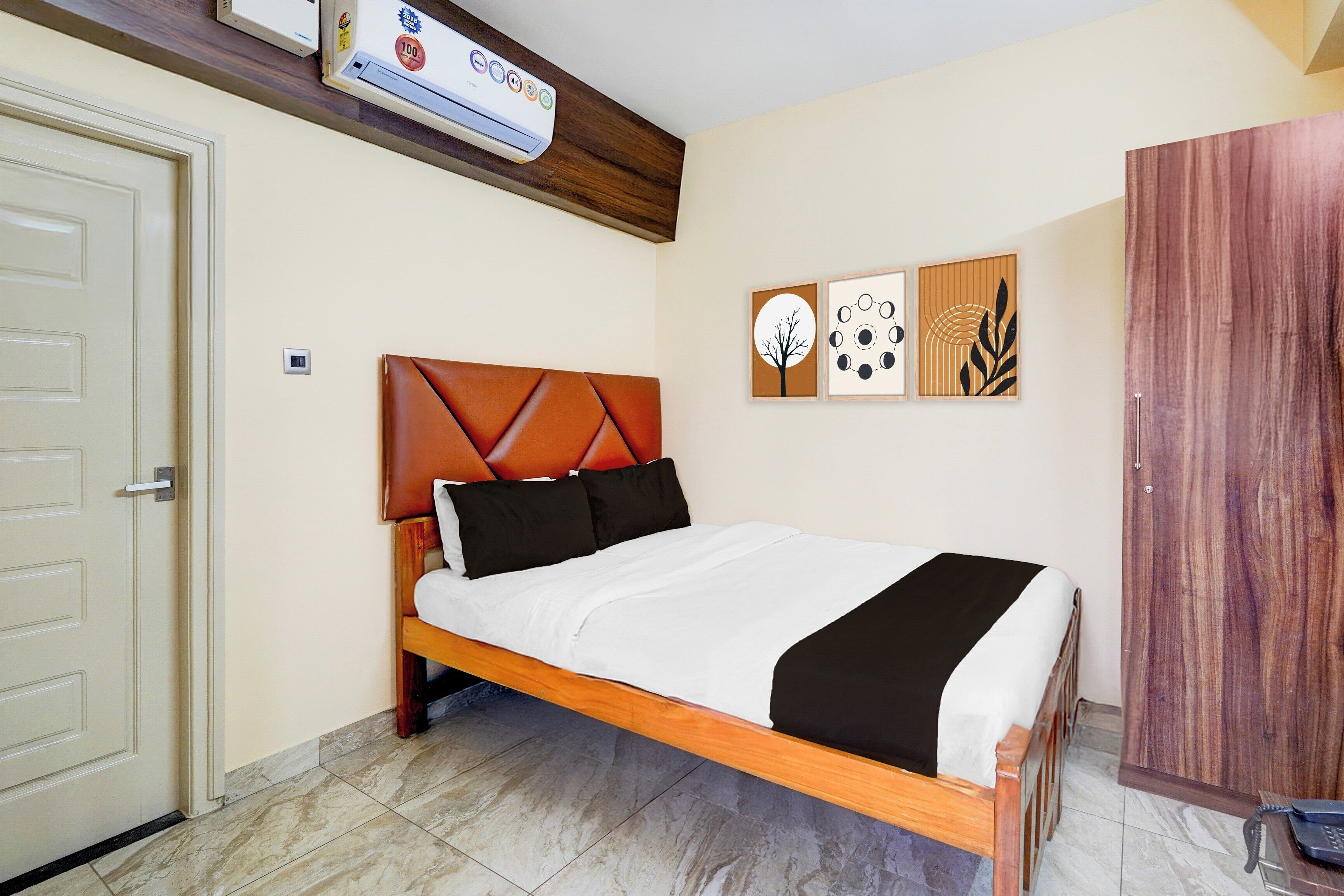 A bedroom with a bed, a wardrobe, and a wall-mounted air conditioner.