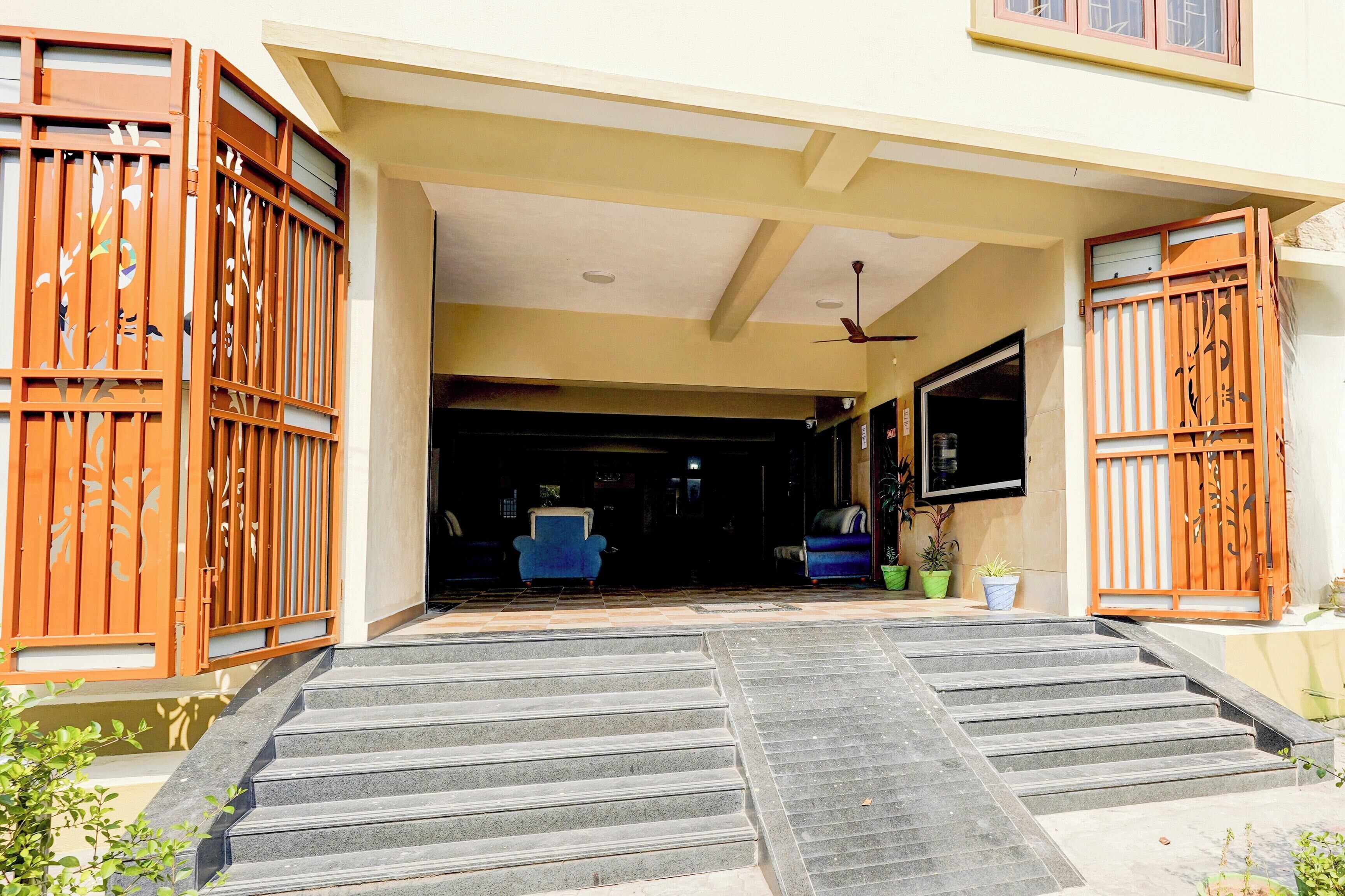 A building entrance with a set of stairs leading up to a door, a ceiling fan, and a TV mounted on the wall.