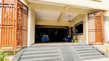 La entrada de un edificio con un conjunto de escalones que conducen a una puerta, un ventilador de techo y un televisor montado en la pared.