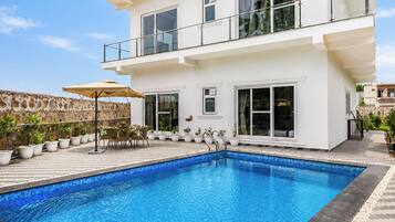 Un edificio de dos pisos con una piscina al frente.