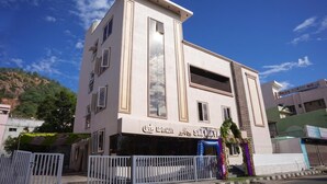 A multi-story building with a flat facade, large windows, and a balcony on the upper floor.