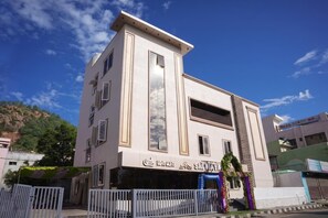 Un edifici d'alguns pisos amb façana plana, grans finestres i un balcó a la planta superior.