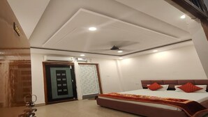 Een slaapkamer met een bed, een plafondventilator en een deur met een geëtste ruit.