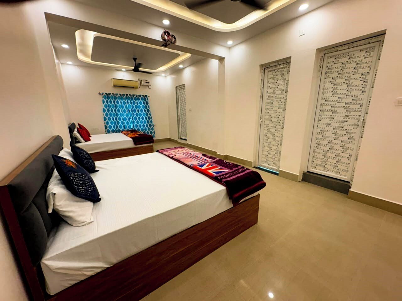 A modern bedroom with a large bed, a ceiling fan, and a window with curtains.