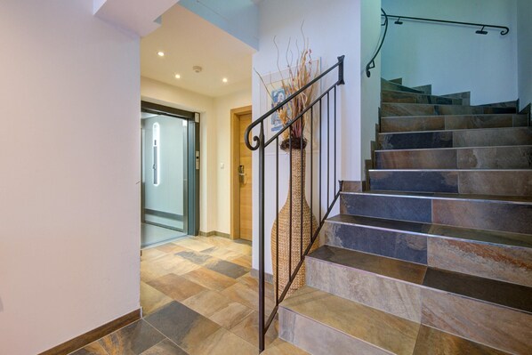 Una escalera con barandilla metálica y una cesta decorativa tejida.