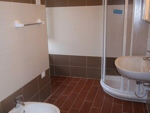 Ein Badezimmer mit Dusche, Waschbecken und Toilette.
