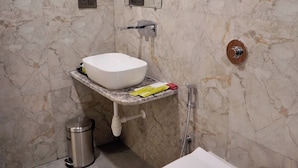 A bathroom with a white sink, a toilet, and a shower. - Hotel Rama Continental Second  (Prayagraj)