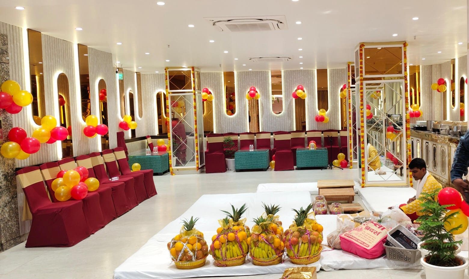 A hotel lobby with seating areas, a reception desk, and a buffet table with fruit baskets.