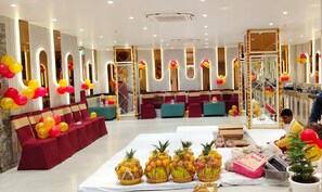 A hotel lobby with seating areas, a reception desk, and a buffet table with fruit baskets. - Hotel Rama Continental Second  (Prayagraj)