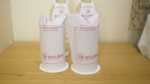 Two glass containers labeled 'Hotel Rama Continental' on a wooden surface. - Hotel Rama Continental Second  (Prayagraj)