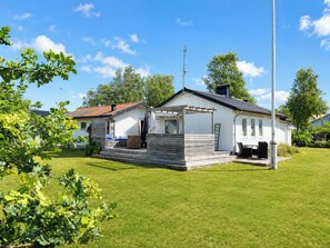A single-story house with a porch, a chimney, and a satellite dish.