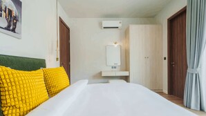 Ein Hotelzimmer mit Bett, Nachttisch, Spiegel und Kleiderschrank.