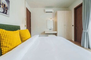 Ein Hotelzimmer mit Bett, Nachttisch, Spiegel und Kleiderschrank.