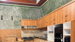 A modern kitchen with wooden cabinets, a black refrigerator, and a marble countertop. - private room with bigger size room, near central canggu,
10minute to the beach (badung)