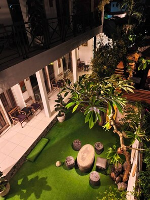 An indoor courtyard with a green lawn, seating area, and potted plants. - private room with bigger size room, near central canggu,
10minute to the beach (badung)