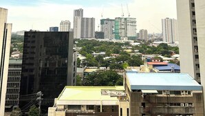 Un paisaje urbano con rascacielos, grúas de construcción y una combinación de edificios residenciales y comerciales.