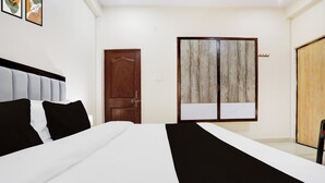 A bedroom with a bed, a wardrobe, and a door. - Super Collection O Nagwa Lanka Varanasi (Varanasi)