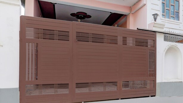 A large, brown metal gate with horizontal bars and a decorative element on the top. - Super Collection O Nagwa Lanka Varanasi (Varanasi)