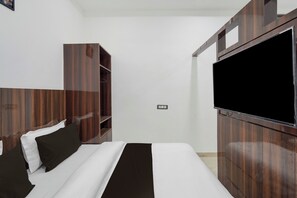 A hotel room with a bed, a wardrobe, and a television. - Super Collection O Banaras Railway (Varanasi)
