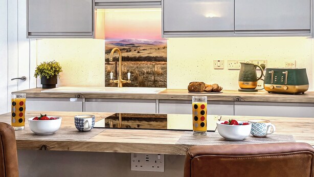 Una cocina moderna con encimera de madera, un fregadero y vistas a un paisaje por la ventana.