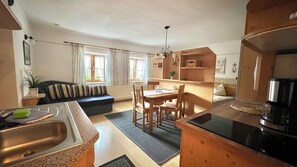A compact living space with a kitchenette, dining area, and a sofa. - Langbürgner See Vacation Apartment, 28 square meters (Rimsting)