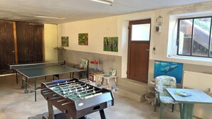 Una habitación con dos mesas de fútbol de mesa, una ventana y una puerta.