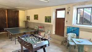 A room with two foosball tables, a window, and a door. - Langbürgner See Vacation Apartment, 28 square meters (Rimsting)