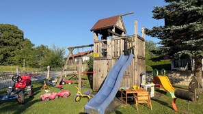 A playground with a wooden slide, swings, and various play structures. - Langbürgner See Vacation Apartment, 28 square meters (Rimsting)