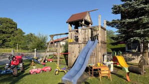 A playground with a wooden slide, swings, and various play structures. - Simssee Vacation Rental, 45 square meters (Rimsting)