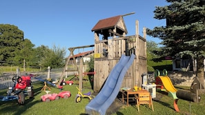 A playground with a wooden slide, swings, and various play structures. - Simssee Vacation Rental, 45 square meters (Rimsting)