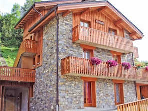 A two-story building with a stone facade and wooden balconies. - Paradis de St.Martin by Interhome (Les Granges)