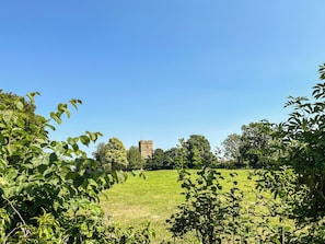 Ein grünes Feld mit einem Turm in der Ferne.
