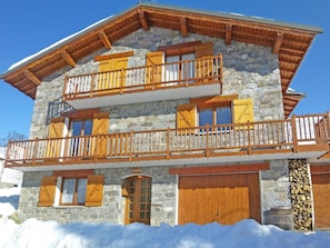 A two-story stone building with wooden balconies and a stone facade. - Flocon de Belleville by Interhome (Les Granges)