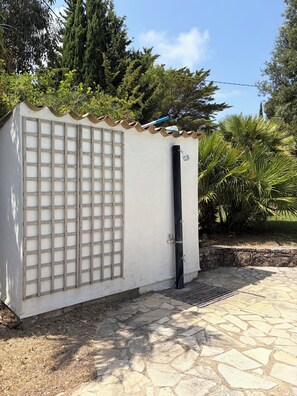A small, white building with a metal grid door and a black pipe. - Spacious villa in a quiet location, 5 bedrooms, private pool, near the ocean (Grimaud)