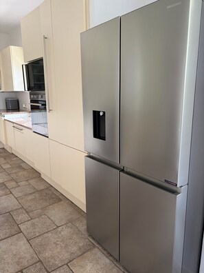A stainless steel refrigerator with a Hisense logo, a microwave, and a built-in oven in a kitchen with beige cabinetry. - Spacious villa in a quiet location, 5 bedrooms, private pool, near the ocean (Grimaud)