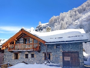 A stone building with a wooden balcony and a snow-covered roof. - Chalet Coeur Paradis by Interhome (Peisey-Nancroix)