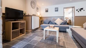 Un salon moderne avec un téléviseur à écran plat, un canapé, une table basse et un radiateur.