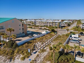 A coastal hotel with a parking area, a beach access walkway, and a view of the ocean. - Crystal Beach Condo | Walk to the Gulf (Destin)
