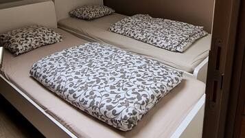 Een stapelbed met beddengoed en kussens met een patroon.