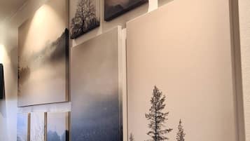 A wall with multiple framed artworks depicting natural landscapes.