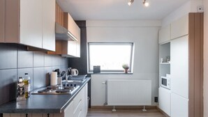 Una cocina moderna con estufa integrada, ventana y radiador blanco.