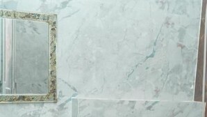 A bathroom with a sink, mirror, and bidet. - SWAGAT GRAND (Bara)