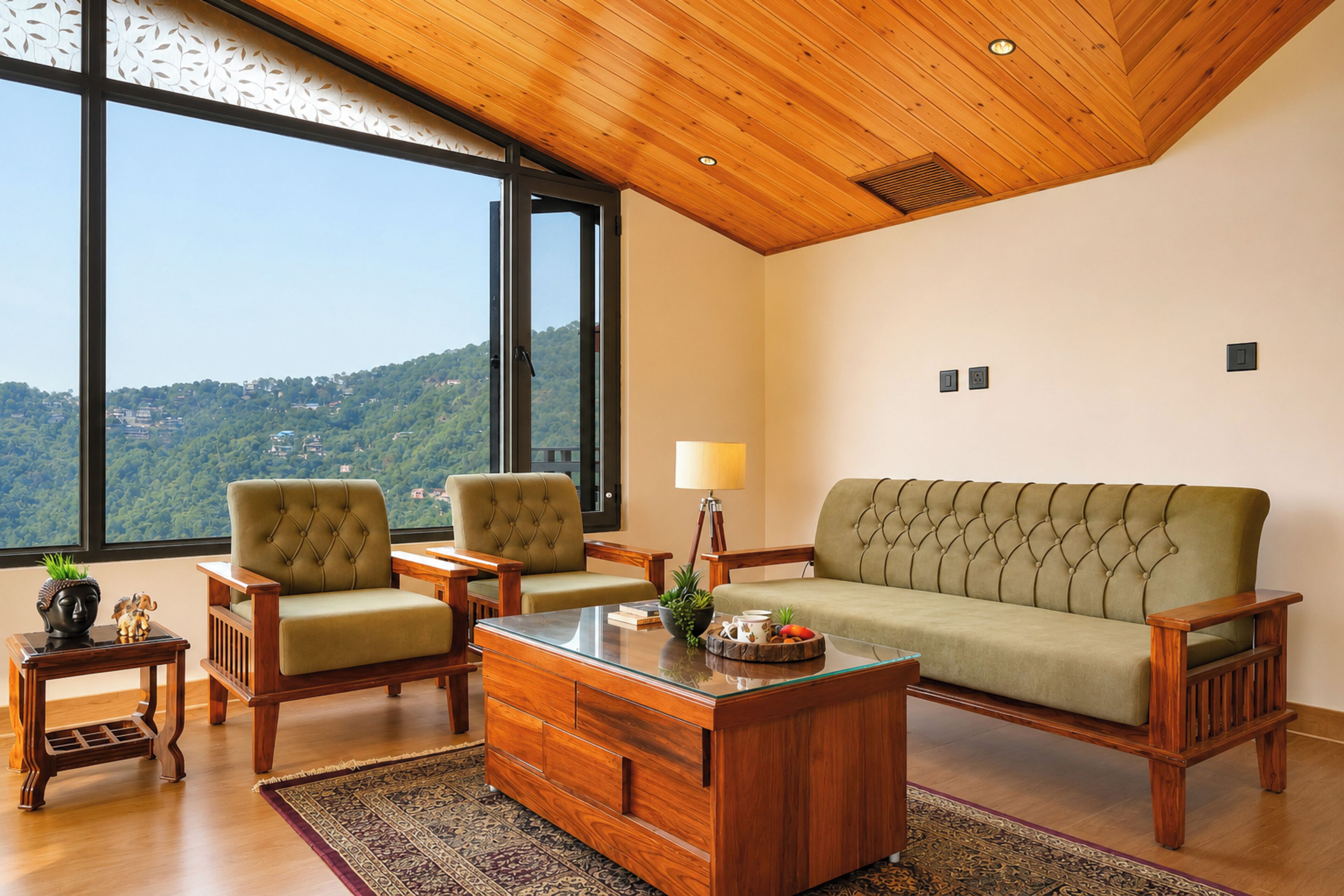 Una habitación con un ventanal grande, un sofá, dos sillones, una mesa de centro de madera y una mesita auxiliar con una lámpara.