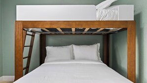 Uma cama beliche com estrutura de madeira e roupa de cama branca.