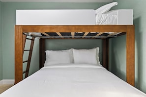 A bunk bed with a wooden frame and white bedding. - Baby Be Sweet by AvantStay | Pool + Gazebo Lounge | Walk to Dining (Oakland Park)