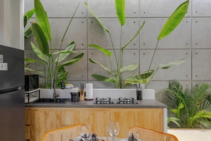 A modern kitchen with a built-in stove, sink, and bar area. - Villa Kartal Altin by Pertama Stay (Badung Regency)