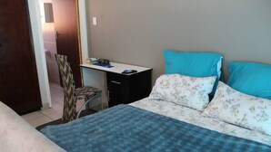 Une chambre à coucher avec un lit, un bureau et une chaise.