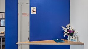A reception desk with a no-smoking sign, a vase of flowers, and a 'BEACH' sign. - Serenity Studio at The Waves (Cowes)