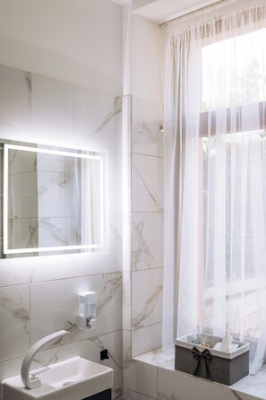 A bathroom with a white sink, a mirror, a shower curtain, and a window with a view. - Vrbo Property (Reichenbach im Vogtland)